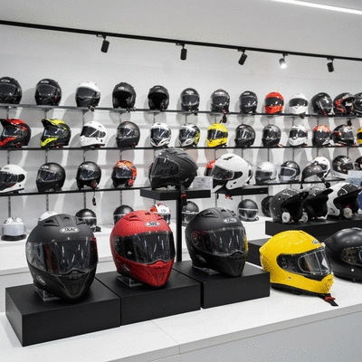 Various motorcycle helmets on display in a store, showing different styles and brands